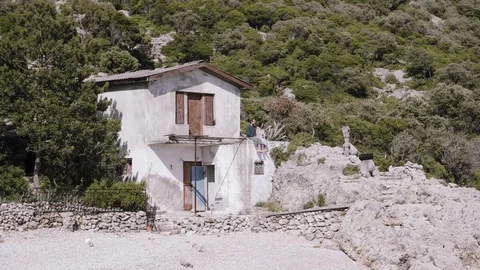 A couple at a house on a remote beach Stock Footage 127696442