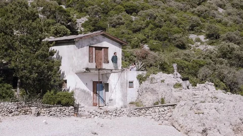 A couple at a house on a remote beach Stock Footage 127696639