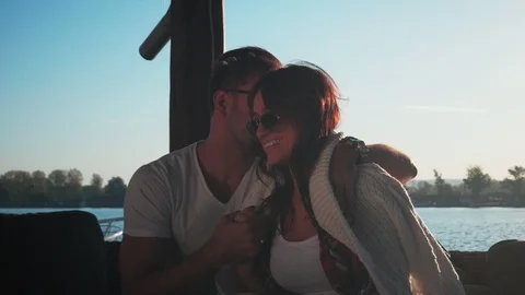 Couple hugging and having fun while sitting by the river Stock-Footage 99399517