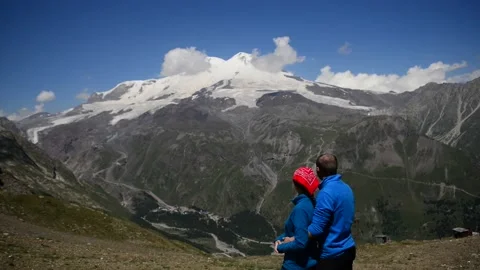 The couple is hugging and looking at Elbrus Stock Footage 226372215