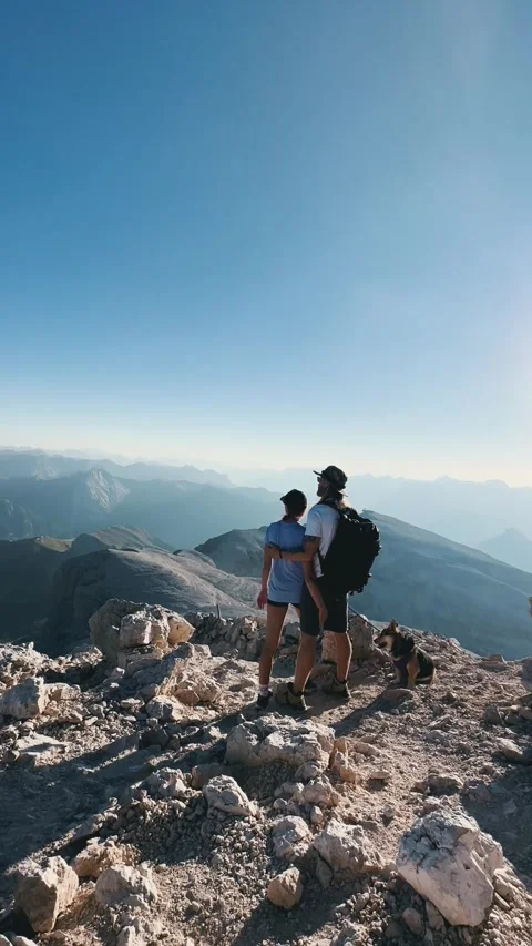 Couple Hugging with Dog on Mountain Summit Stock Footage 329775876