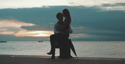 Couple hugging each other at sunset in front of the sea Stock Footage 204915831