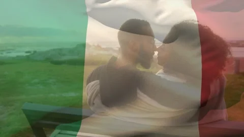 Couple hugging on seat causing leaning in for kiss, tricolor flag overlay waving Vídeo Stock 329471933