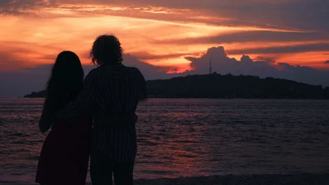 Couple hugging silhouettes in front of ocean sunset Video stock 79085906