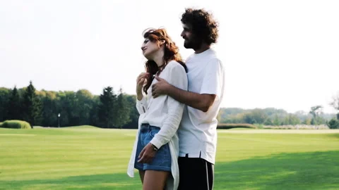 Couple hugging, talking, standing on the green grass. Stock Footage 106411019