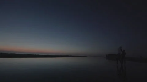 Couple ignites a floating asian lantern at the ocean - static shot Stock Footage 40900736