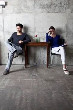 A couple ignoring each other while reading separate magazines Stock Photos