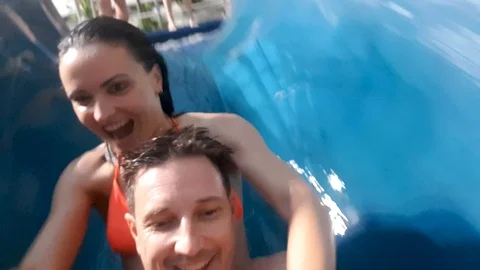 A couple on an indoor waterslide Stock Footage 98623073