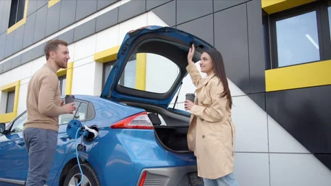 Couple install charger plug from charging station to electric car Video stock 242185836
