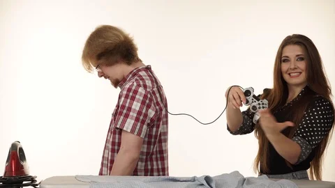 Couple ironing clothes, female dominates guy 4K Stock Footage
