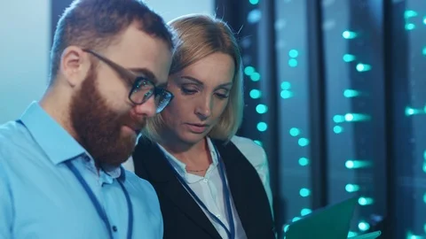Couple of IT server engineers coworking running diagnostics operations in rack Stock Footage 120481760