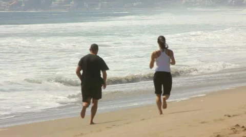 COUPLE JOG ON BEACH SLO-MO Stock Footage 5652226