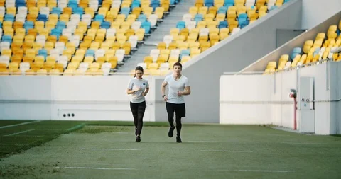 Couple of Joggers on Stadium Видео 112434255
