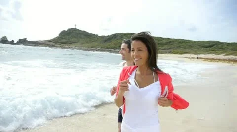 Couple jogging on the beach by the sea Stock Footage 14827498