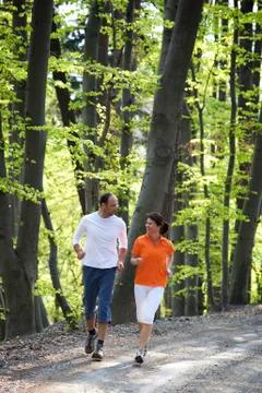 Couple jogging in beech forest Stock Photos