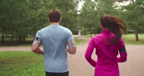 Couple Jogging Through Park Pathway Stock Footage 327446279