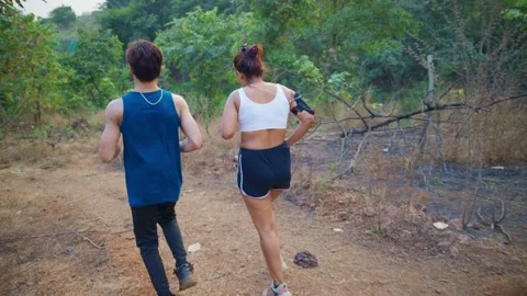 Couple jogs down the forest path enjoying fresh air Stock Footage 298236924