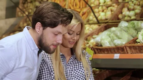 Couple joyfully selecting fresh vegetables at the supermarket Video stock 311537297