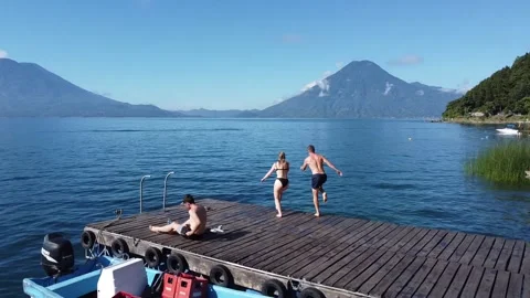 Couple jumping into a lake 動画素材 254319915