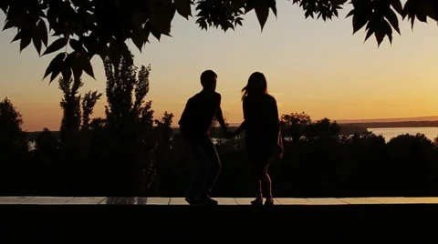 Couple jumping om sunset background Stock Footage 65595366