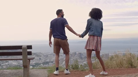 Couple jumping overlooking the city Stock Footage 107373252