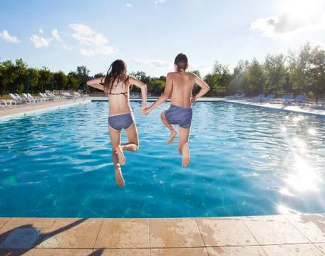 Couple jumping into pool Stock Photos
