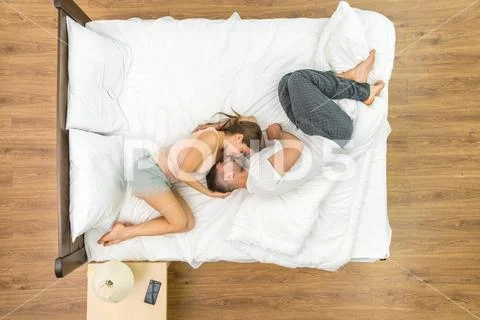 The couple kiss in the bed. View from above Stock Photos