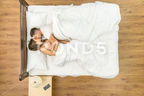The couple kiss in a bed. View from above Stock Photos
