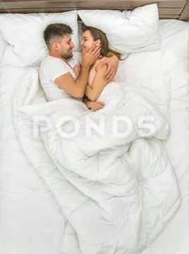 The couple kiss in the white linens. View from above Stock Photos