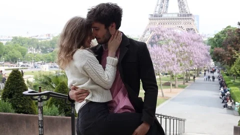 Couple kissing in front of Eiffel tower in Paris, France Stock Footage 98093894
