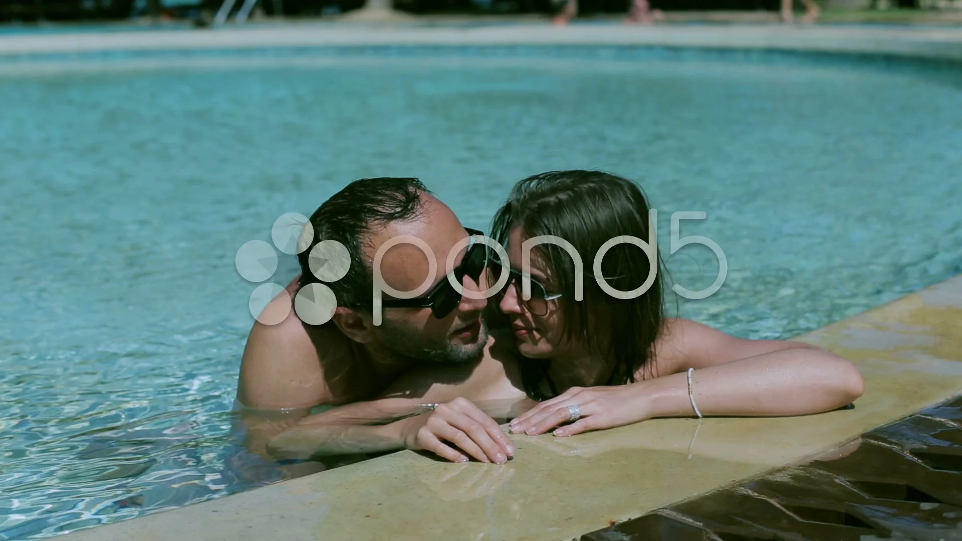 Couple kissing in the pool, steadycam shot