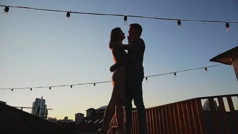Couple kissing while standing on rooftop during sunset Stock Footage 168841109