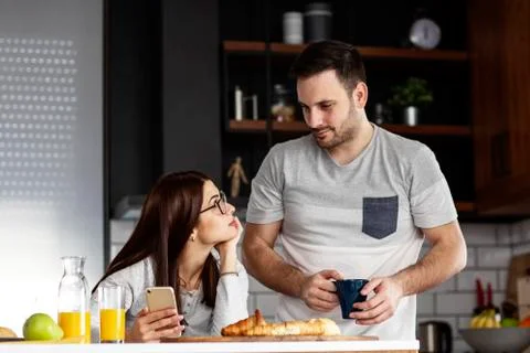 Couple in the kitchen at breakfast time Stock Photos