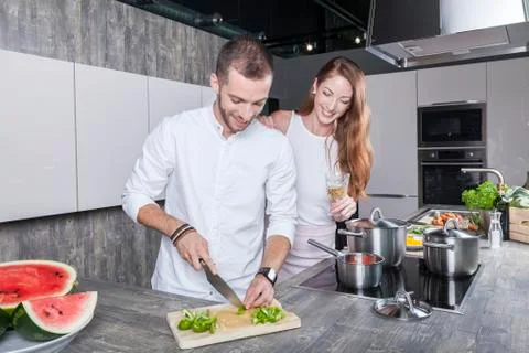 Couple in the kitchen cooking Stock Photos