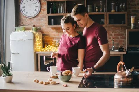 A couple in the kitchen is preparing coffee Stock Photos