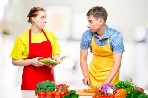 Couple in the kitchen preparing fresh vegetable salad Stock Photos