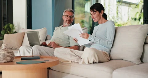 Couple, laptop and reading with documents on sofa for finance, bills or 库存影片 335515608