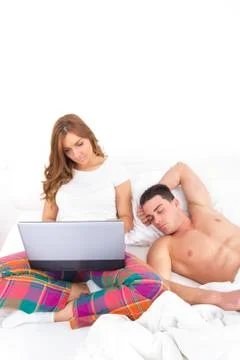 Couple with laptop computer in bed Stock Photos