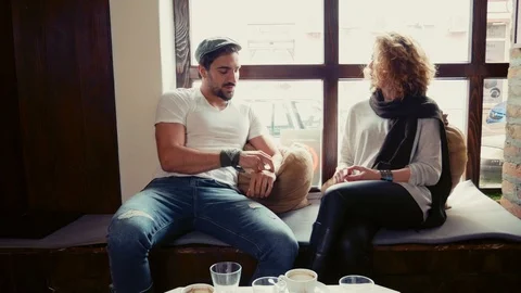 Couple laughing in in a cafe by the window 스톡 동영상 95909120