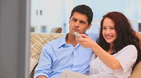 Couple laughting in front of the tv Stock Footage 1098486