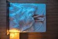 The couple lay under blanket on the bed. evening night time. view from above Photo