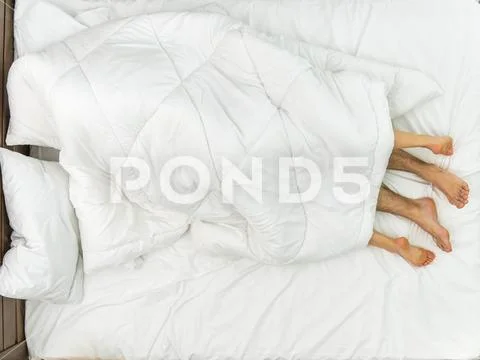 The couple lay under the cover. View from above Stock Photos