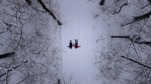Couple laying down on snow camera goes up Video stock 149624571