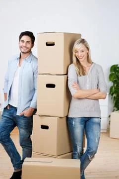 Couple leaning on stack of cardboard boxes Foto stock