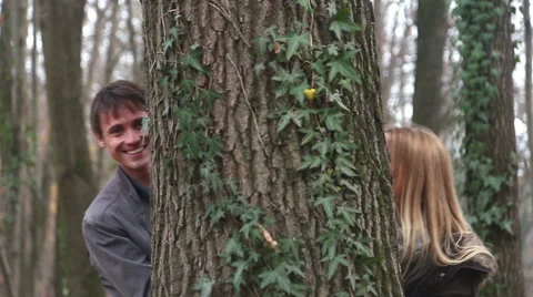 Couple leaning on tree, looking and waving Stock Footage 59554023