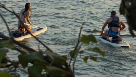 Couple learning to SUP board in lake Paranoa on sunny summer afternoon Vídeos de archivo 210214509