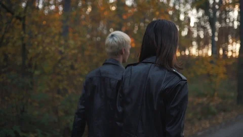 Couple in leather jackets walks in forest Stock Footage 91775671