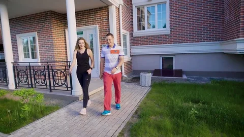 Couple leaving the building and starting to run. Morning jogging before the work Stock Footage