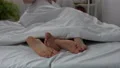 Couple legs in bed, lovers making love under blanket, intimate relations passion 4k or 4k+ Resolution