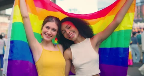 Couple lesbian posing with rainbow flag at city street. Stock Footage 243394576